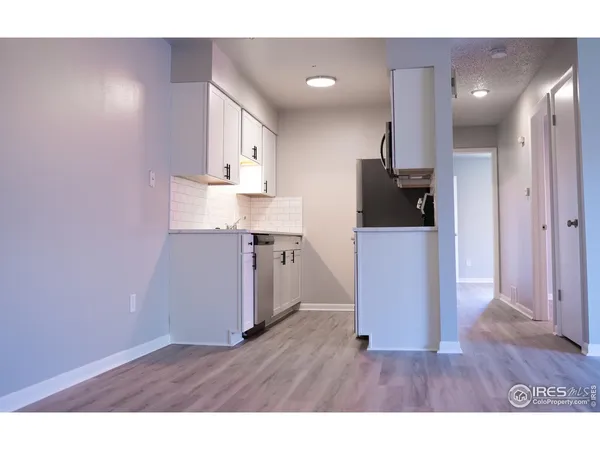 a open kitchen with a sink and wooden floor