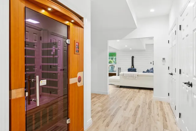 a living room with furniture large window and wooden floor