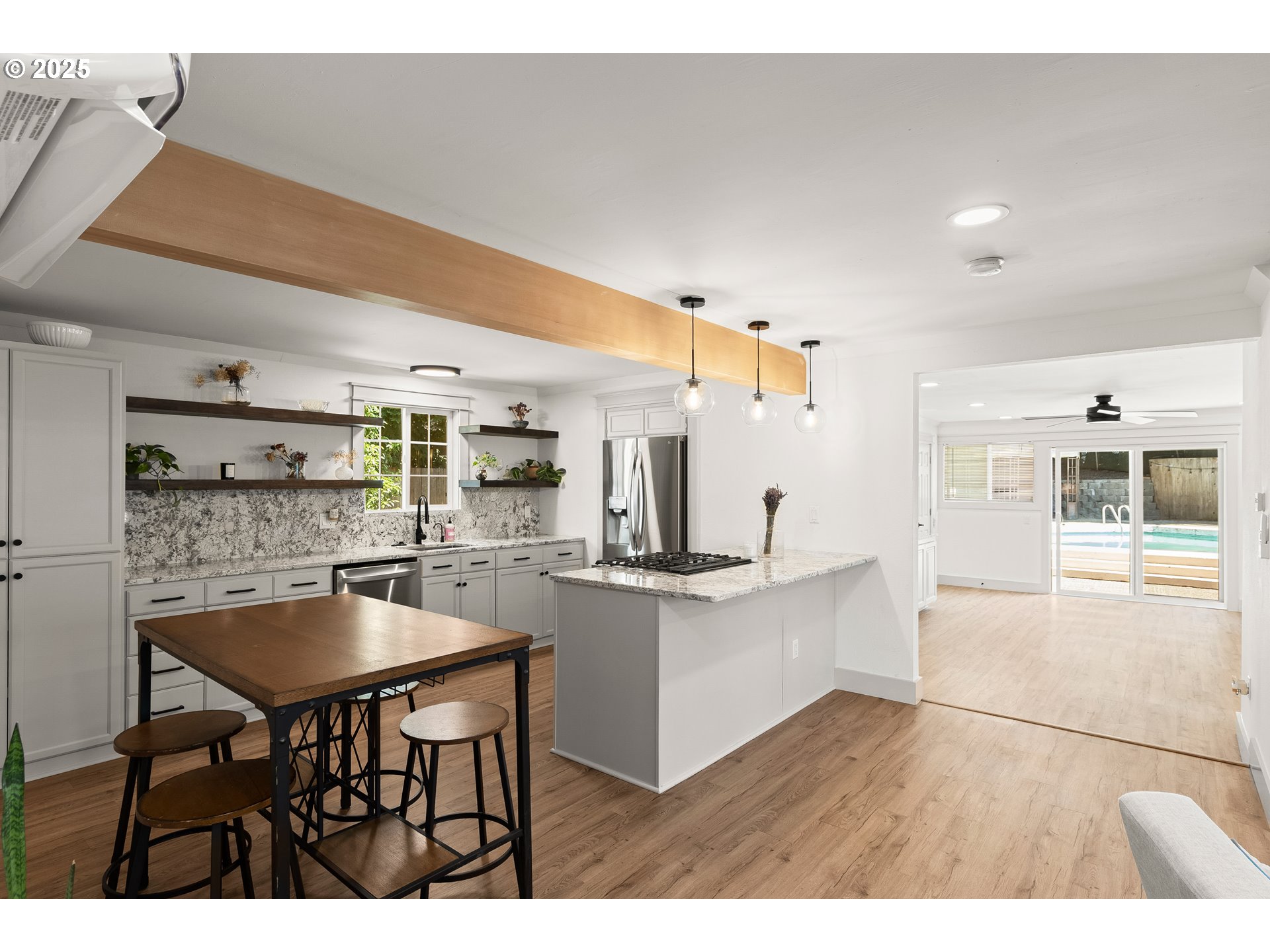 22692 Southwest Highland Drive Sherwood, OR 97140 - Photo 6 of 26 a kitchen with stainless steel appliances kitchen island granite countertop a table chairs sink and cabinets