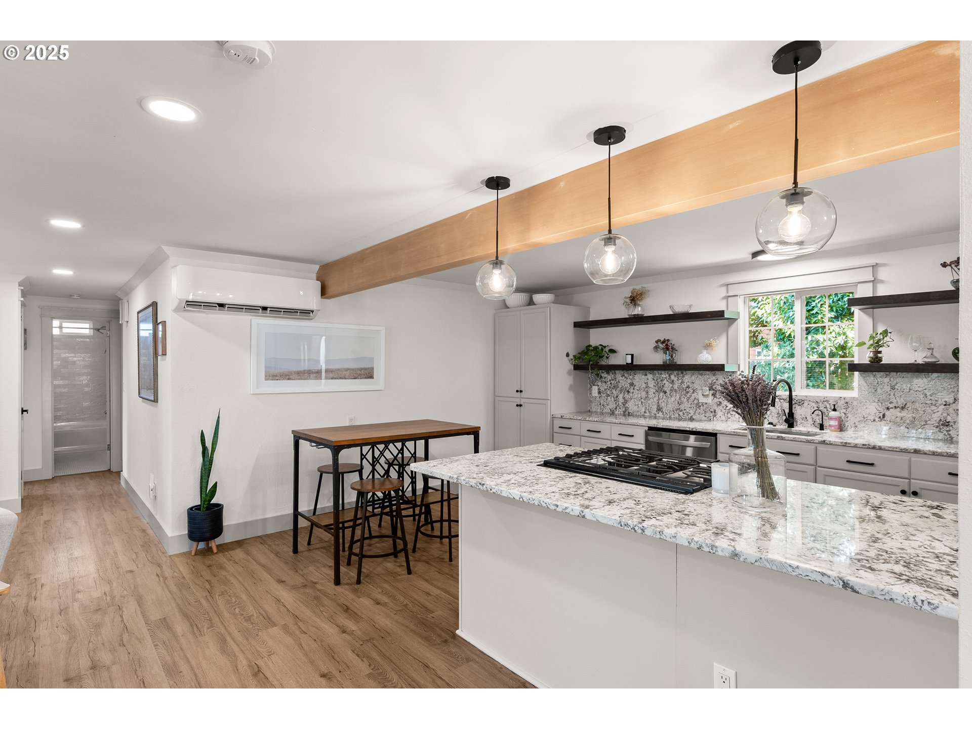 22692 Southwest Highland Drive Sherwood, OR 97140 - Photo 7 of 26 a kitchen with stainless steel appliances kitchen island a table chairs in it and wooden floors