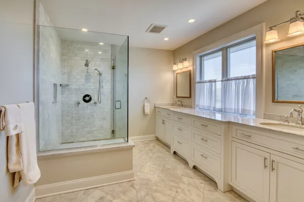 a bathroom with a double vanity sink toilet and shower