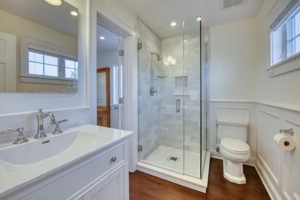 a bathroom with a sink a toilet and shower