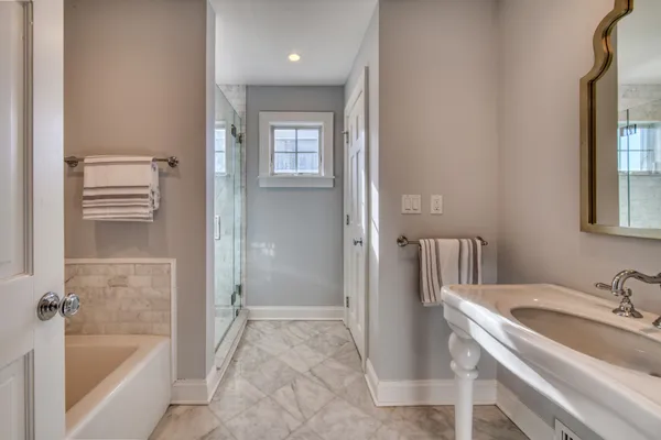 a bathroom with a tub sink and mirror