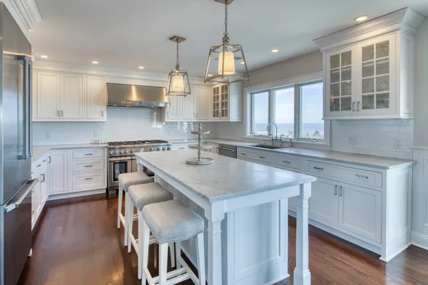 a kitchen with stainless steel appliances granite countertop a sink a stove and a wooden floors
