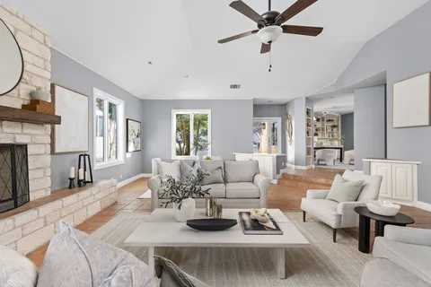 a living room with furniture fireplace and a large window