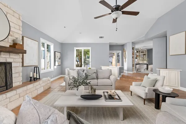 a living room with furniture fireplace and a large window
