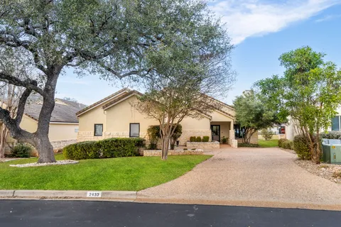 a front view of a house with a yard and trees