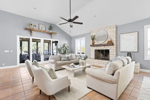 a living room with furniture fireplace and a large window