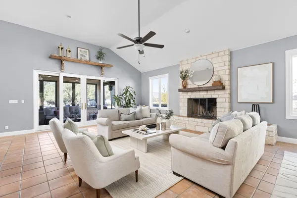 a living room with furniture fireplace and a large window