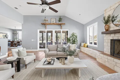 a living room with furniture fireplace and a large window