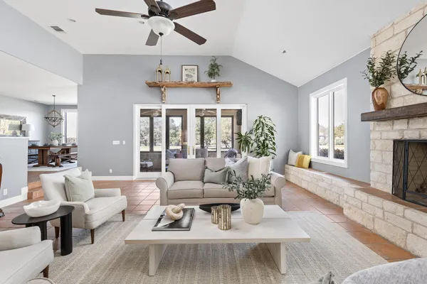 a living room with furniture fireplace and a large window