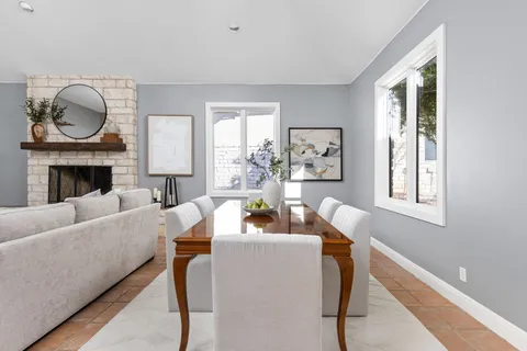 a living room with furniture a rug a fireplace and a window