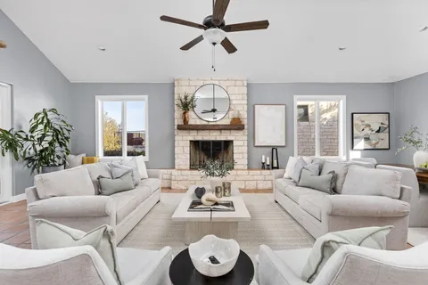 a living room with furniture a fireplace and a chandelier