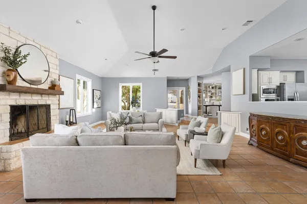 a living room with furniture a fireplace and a chandelier