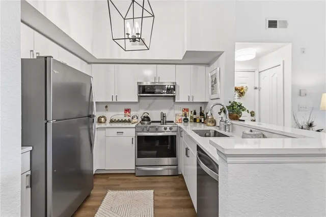 a kitchen with stainless steel appliances granite countertop a stove and white cabinets