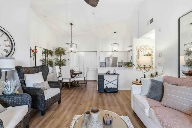 a living room with furniture a clock on wall and a table