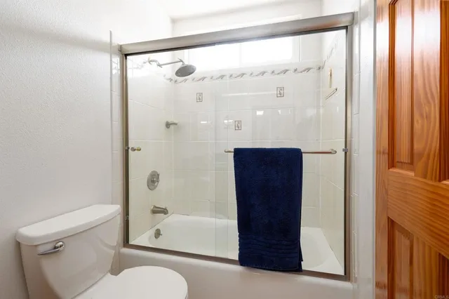 a bathroom with a shower a toilet and a sink