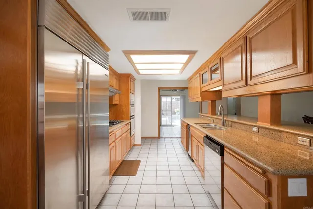 a kitchen with stainless steel appliances granite countertop a refrigerator and a stove
