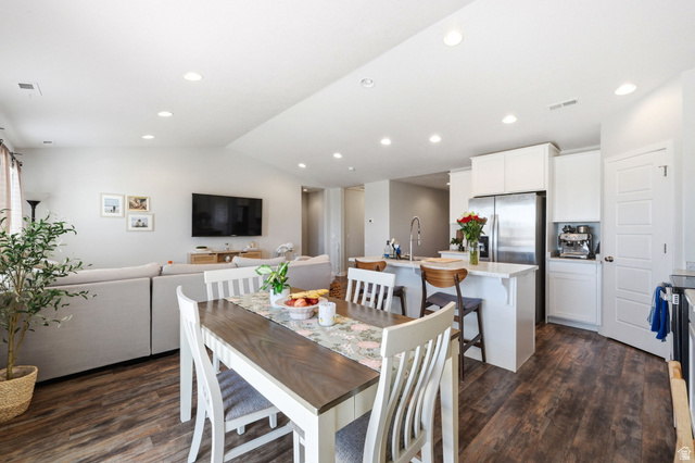 1175 Silver Hollow Road Syracuse, UT 84075 - Photo 11 of 34 Open-concept living space featuring wood-finish flooring, recessed lighting, and a white kitchen with stainless steel appliances
