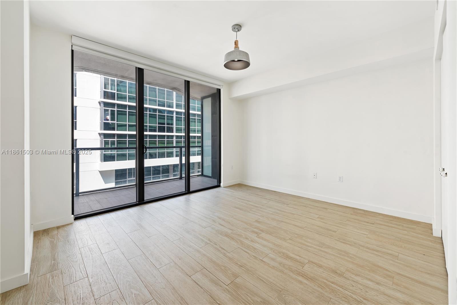 201 Southwest 17th Road, Unit 502 Miami, FL 33129 - Photo 14 of 17 a view of an empty room with wooden floor and a window