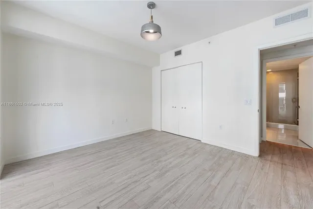 a view of an empty room with wooden floor