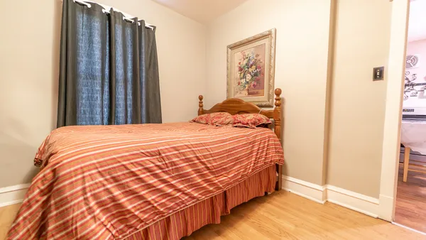 a bedroom with a bed and wooden floor