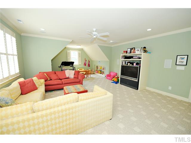 1336 Banbury Road Raleigh, NC 27607 - Photo 11 of 12 a living room with furniture gym equipment and a chandelier