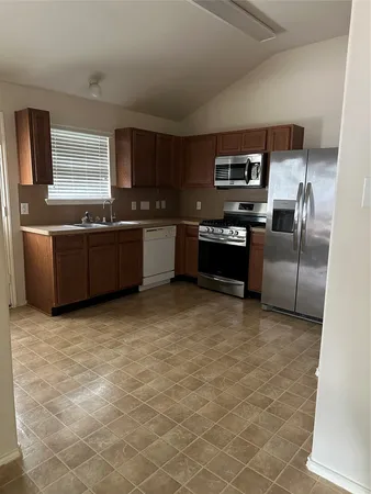 a large kitchen with cabinets and stainless steel appliances