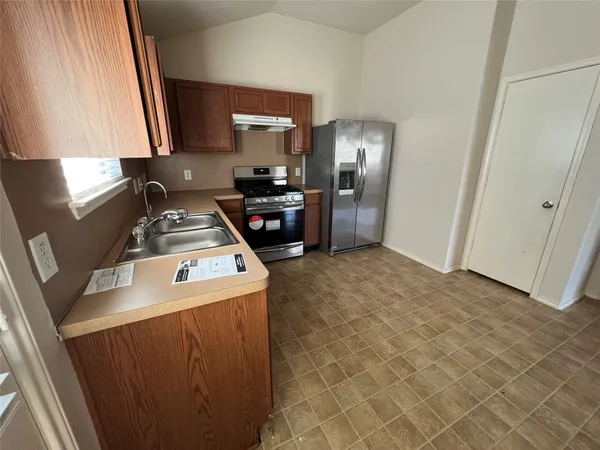 a kitchen with a stove a refrigerator and a sink