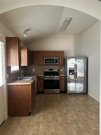 a kitchen with stainless steel appliances granite countertop a stove a sink and a refrigerator