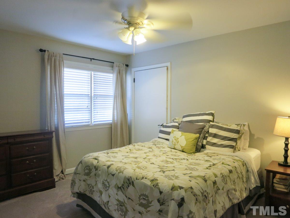 912 Hardimont Road Raleigh, NC 27609 - Photo 15 of 25 a bedroom with a bed and a chandelier