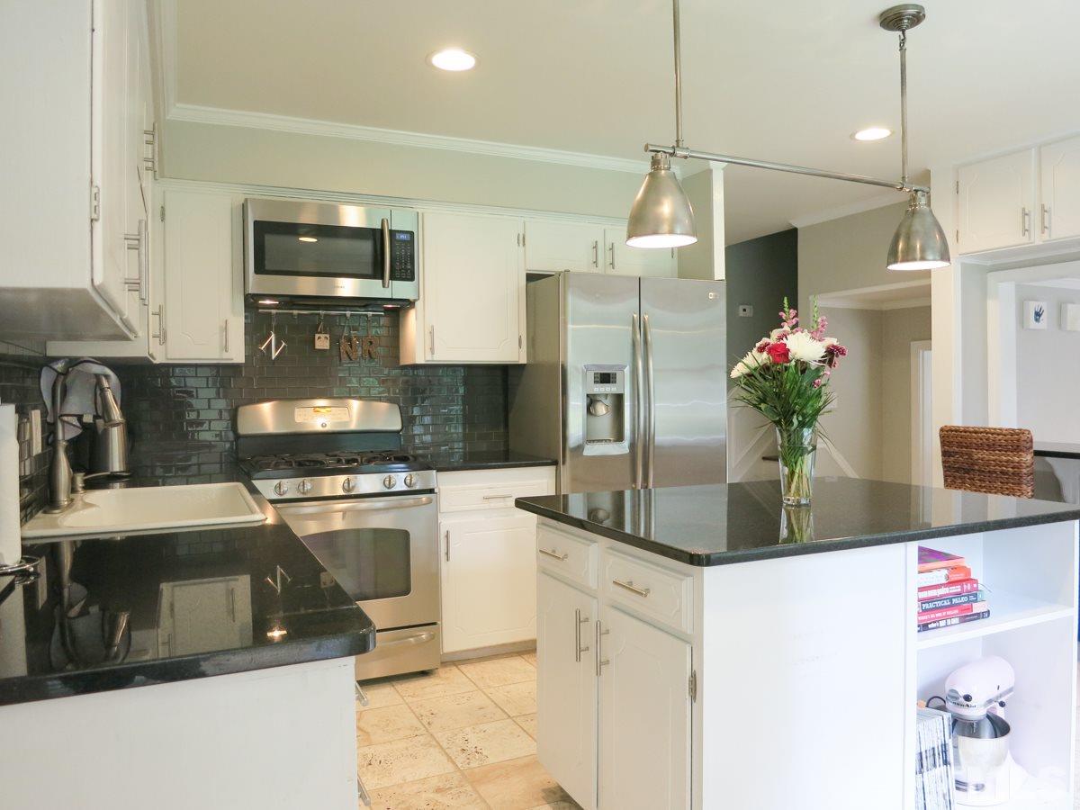 912 Hardimont Road Raleigh, NC 27609 - Photo 8 of 25 a kitchen with stainless steel appliances granite countertop a sink refrigerator and microwave