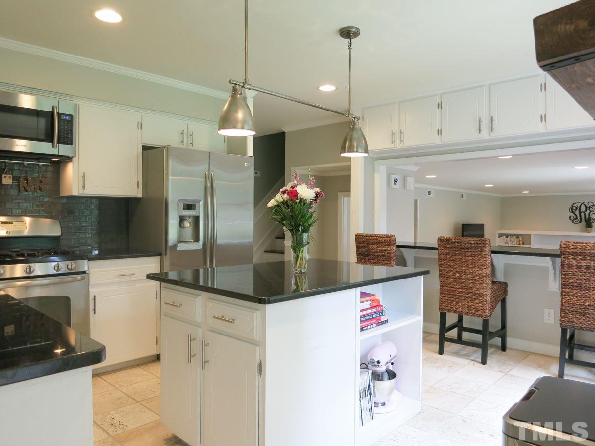 912 Hardimont Road Raleigh, NC 27609 - Photo 10 of 25 a kitchen with stainless steel appliances kitchen island granite countertop a refrigerator and microwave