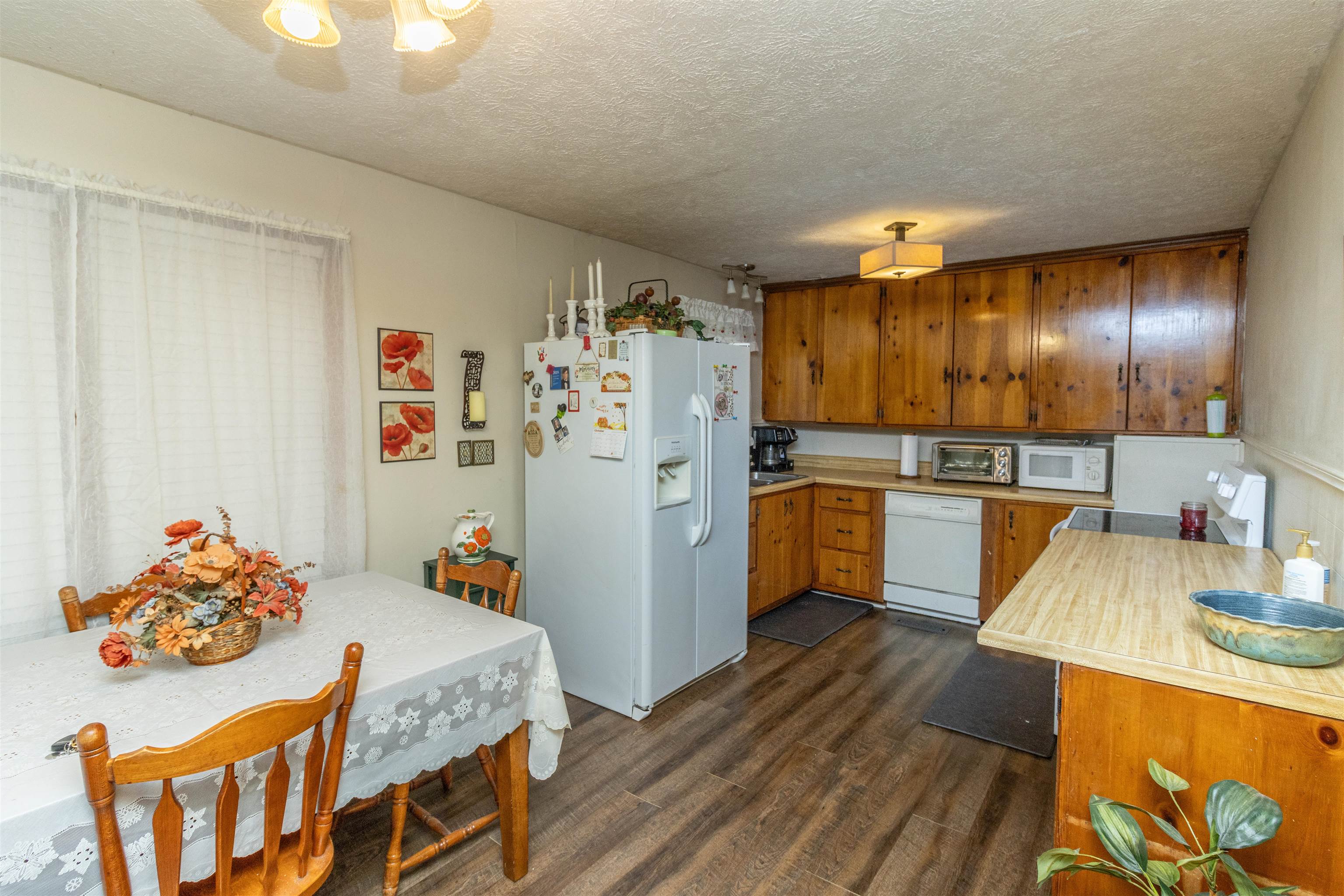 33 Skyline Road Selmer, TN 38375 - Photo 8 of 19 Kitchen featuring a textured ceiling, dark hardwood / wood-style floors, and white appliances