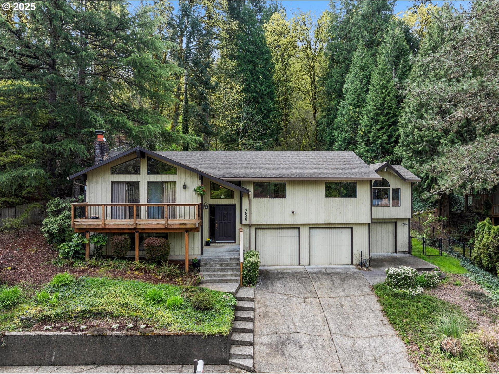 a view of a house with a yard and large trees