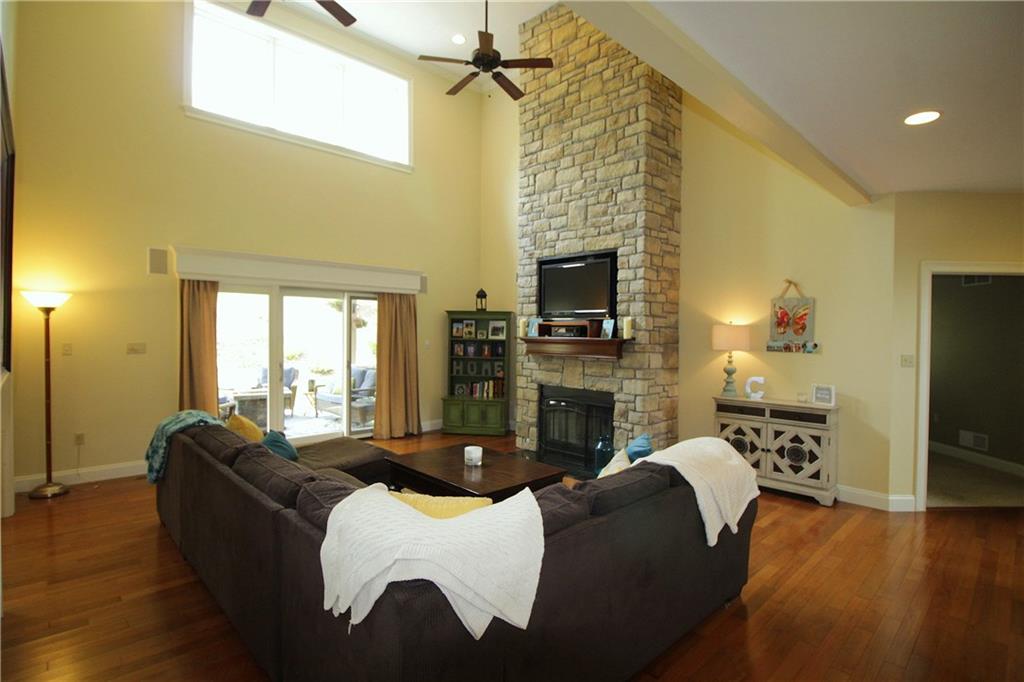 2138 Beams Run Road Jefferson Hills, PA 15025 - Photo 5 of 25 The great room has hardwood flooring and a dramatic floor to ceiling stone fireplace. Sliding door leads to covered patio.