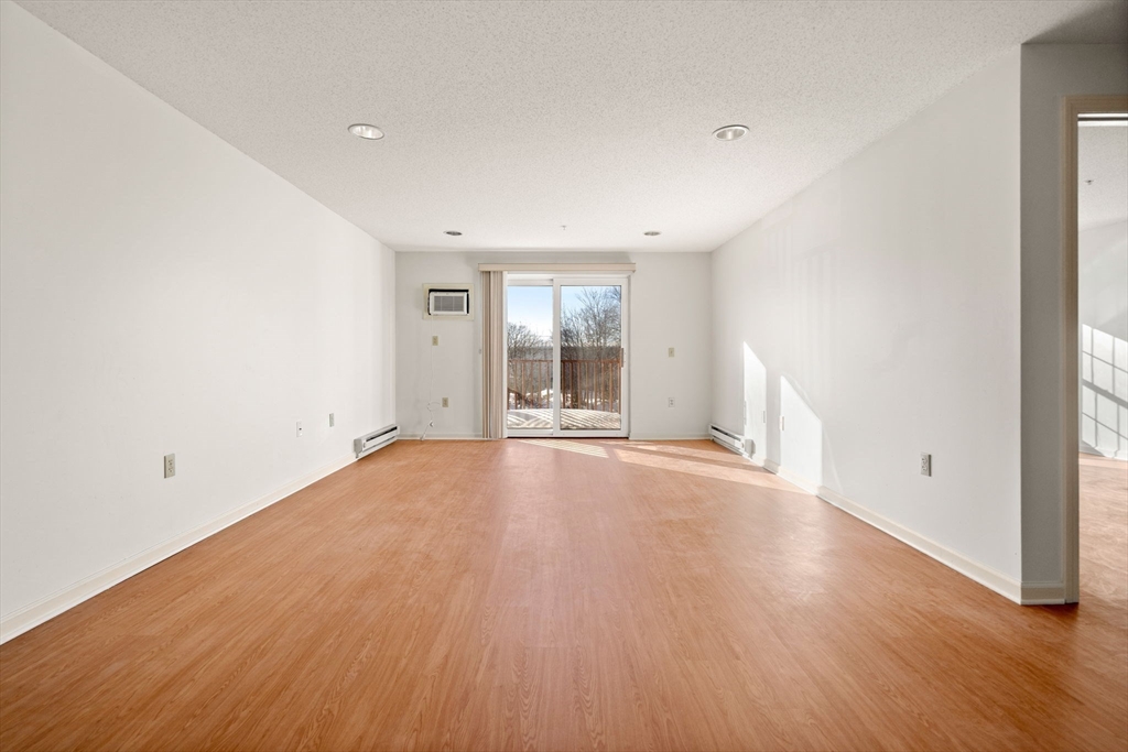 2 Ocean Avenue, Unit 2K Gloucester, MA 01930 - Photo 11 of 26 an empty room with wooden floor and windows