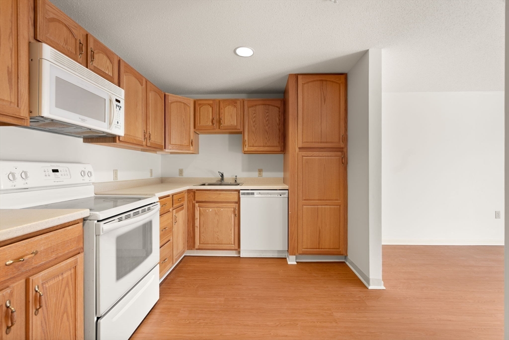 2 Ocean Avenue, Unit 2K Gloucester, MA 01930 - Photo 15 of 26 a kitchen with white cabinets and white appliances