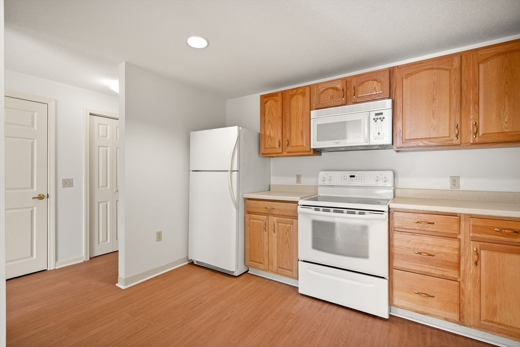 2 Ocean Avenue, Unit 2K Gloucester, MA 01930 - Photo 25 of 26 a kitchen with white cabinets and white appliances