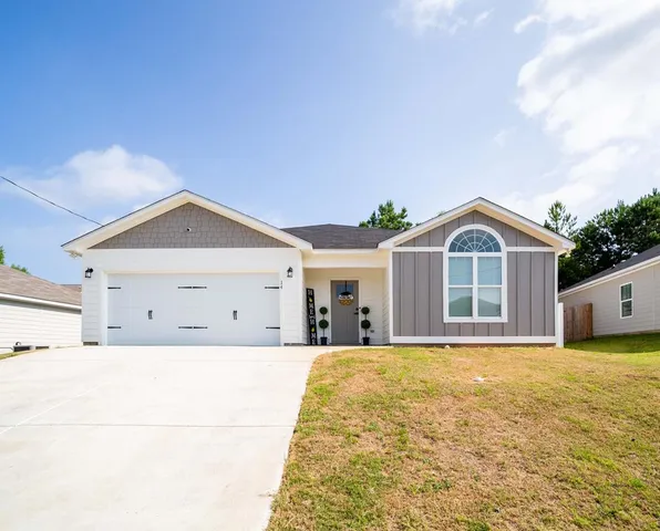 a view of a house with yard and sitting area