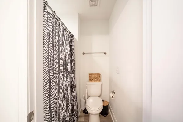 a bathroom with a toilet and a shower curtain