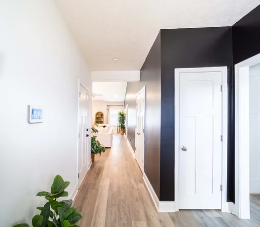 a hallway with wooden floor and a potted plant