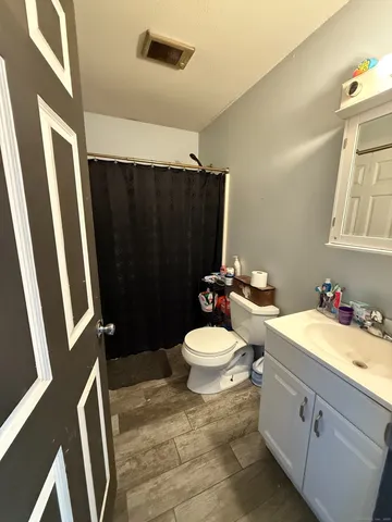 a bathroom with a toilet a sink a vanity and mirror