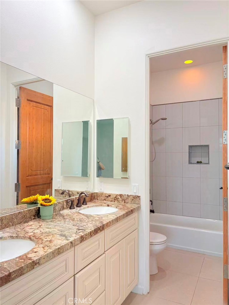 564 Vía Pueblo Riverside, CA 92507 - Photo 17 of 36 a bathroom with a granite countertop sink and mirror with bathtub