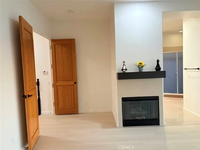 a view of an empty room with a fireplace and a window