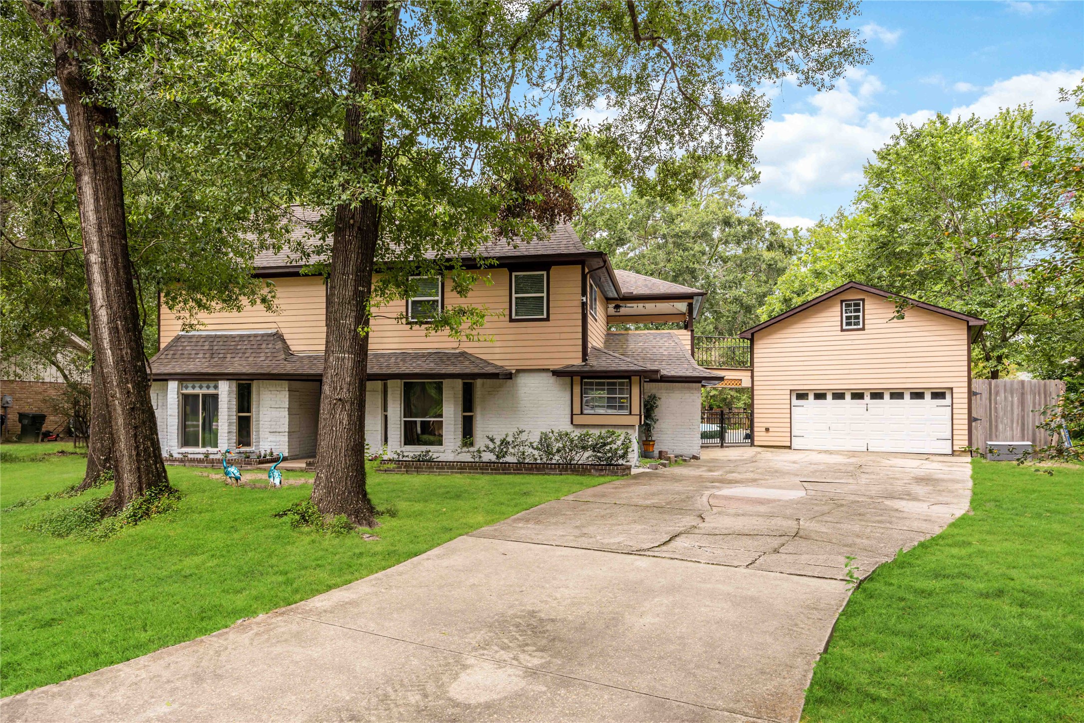 a front view of a house with a garden and trees