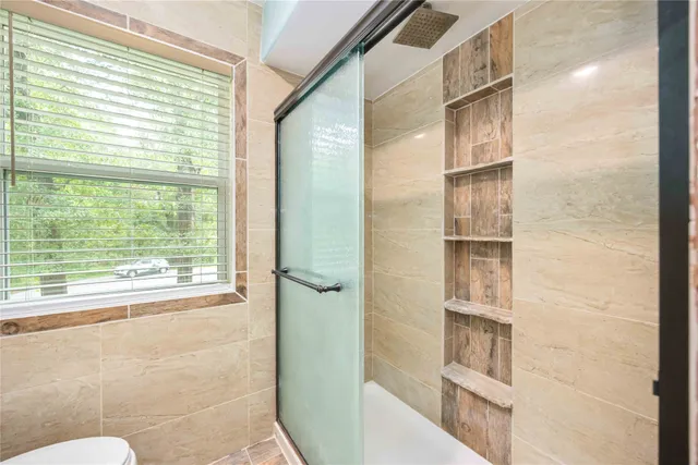 a bathroom with a window and a shower