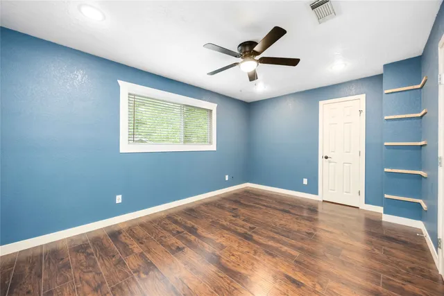 a view of a big room with wooden floor and windows