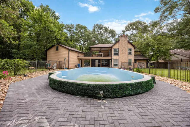 a view of house with yard outdoor seating and covered with tree