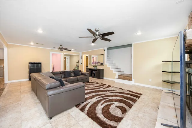 a living room with furniture and a ceiling fan